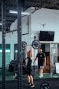 Man In Black Tank Top Lifting Barbell At The Gym