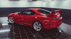 A striking red Toyota Supra sits elegantly in a modern garage with glossy tile flooring, showcasing its sporty design.